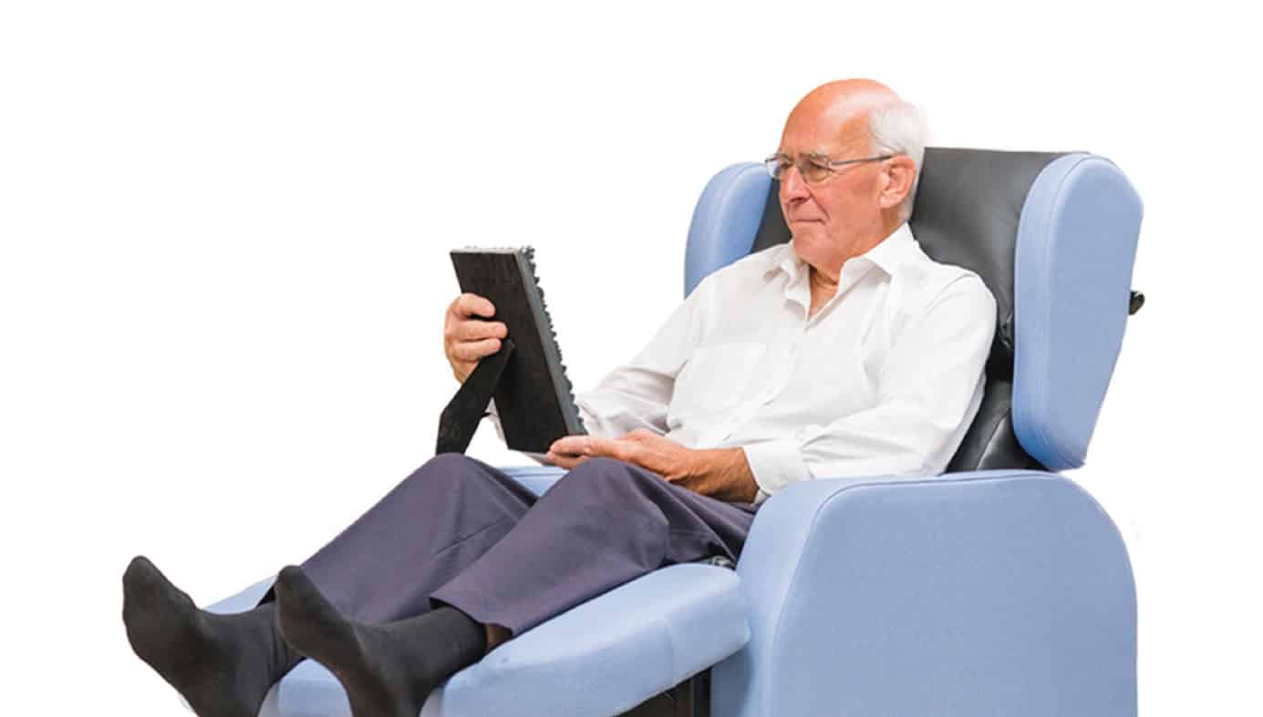 older man in chair looking at photo